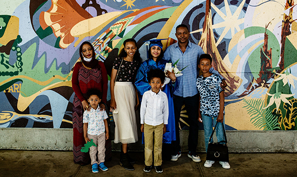  North graduate with family in front of mural 