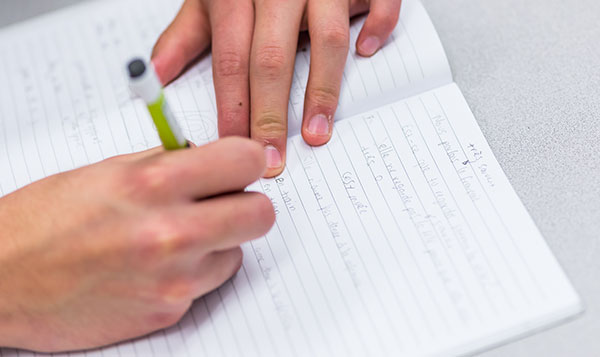  Student's hands at desk 