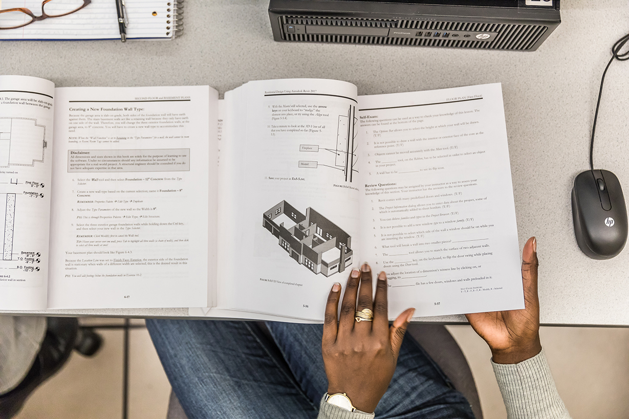 Hands at desk with computer mouse.