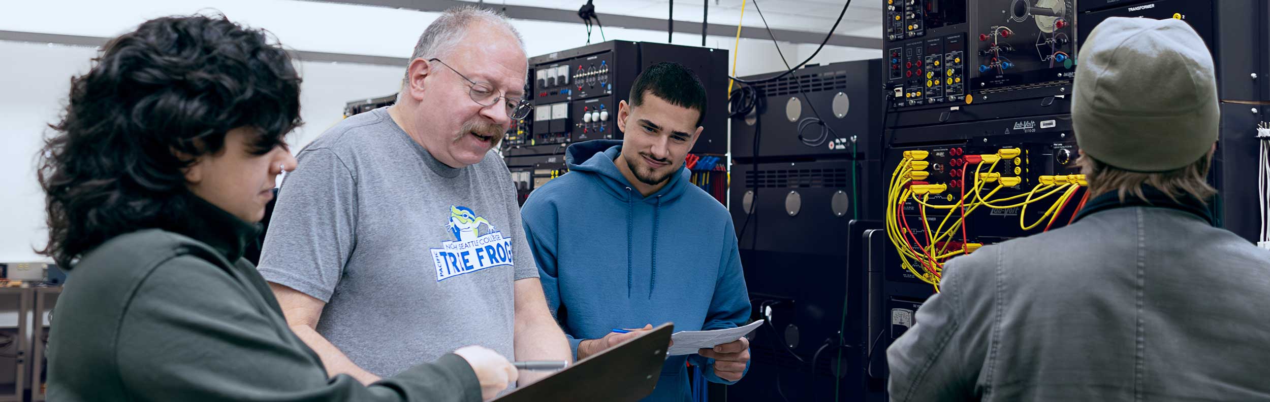  students standing in front of electronics equipment 